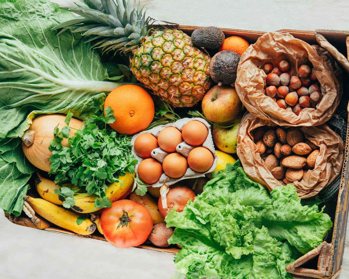 Mesa com fruta e legumes frescos, base de uma alimentação saudável